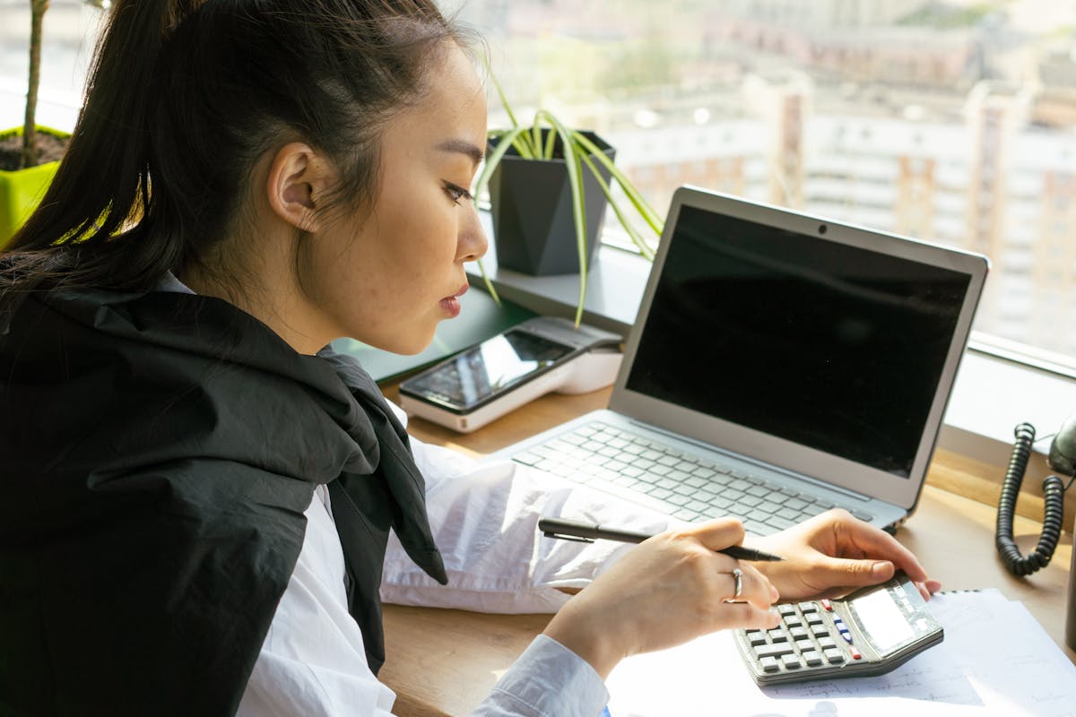 Accountant working at desk with calculator